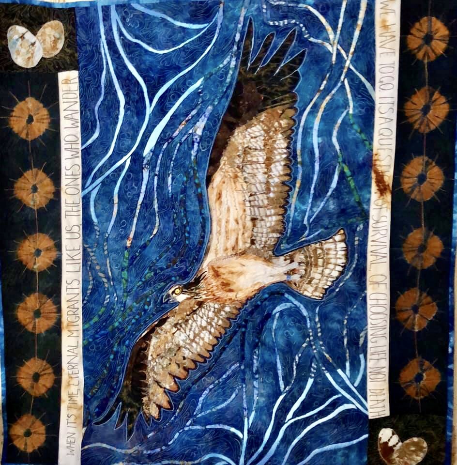 An osprey flies with spread wings across the centre of this quilt. From below, the details of its feathers are sharp. The dark blue sky is turbulent. Tie-dyed circles in vertical lines decorate the side edges.