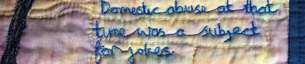 Hand-dyed fabric quilted with many lines. A thin dark tree trunk along the left edge branches into autumn leaves. Much of the rest of the image is covered by stitched text that looks like handwriting. It reads: When the police came to the house it was only because the neighbours reported disturbances. Domestic abuse at that time was a subject for jokes. It has taken over sixty years before I felt able to talk about it openly.