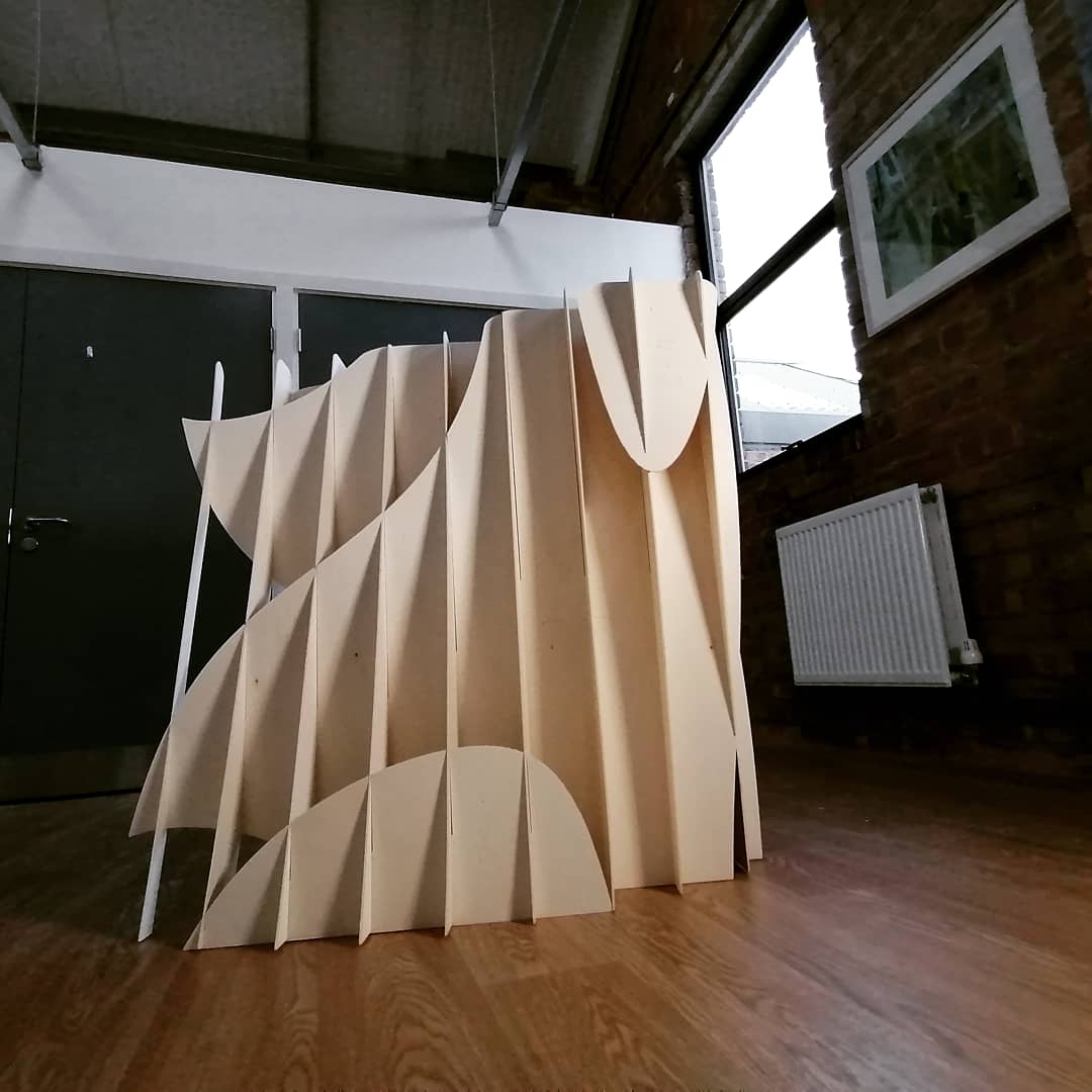 a different perspective of the sculpture from the front showing slats of the plywood form, the vertical slats have a wavy plywood cut out behind and again are designed to show movement of the body connected to Tourettes